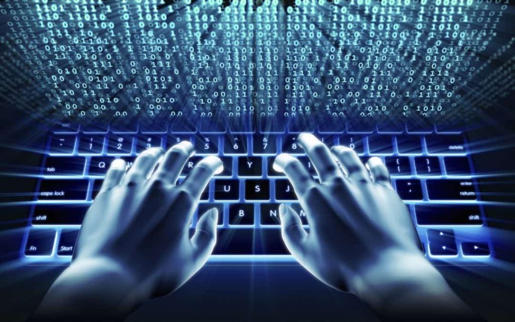 two hands work on laptop keyboards in cyber security 
